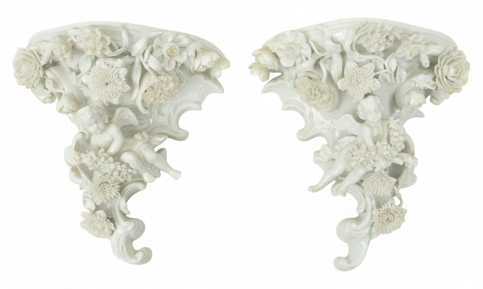 Pair of (German) Blanc De Chine Wall Shelves H 7" W 6.5" Depth 3.8": Pair of (German) Blanc De Chine Wall Shelves H 7" W 6.5" Depth 3.8" High relief angels in floral and leaf . Blue underglaze marks on verso. Provenance: Property from a Bloomfield Hills, MI private col