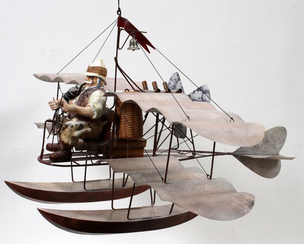 MOBILE MAN IN A BIPLANE, H 30", L 29", D 24": MOBILE MAN IN A BIPLANE, H 30", L 29", D 24":Depicting a man in a biplane with pontoons and a ships wheel.