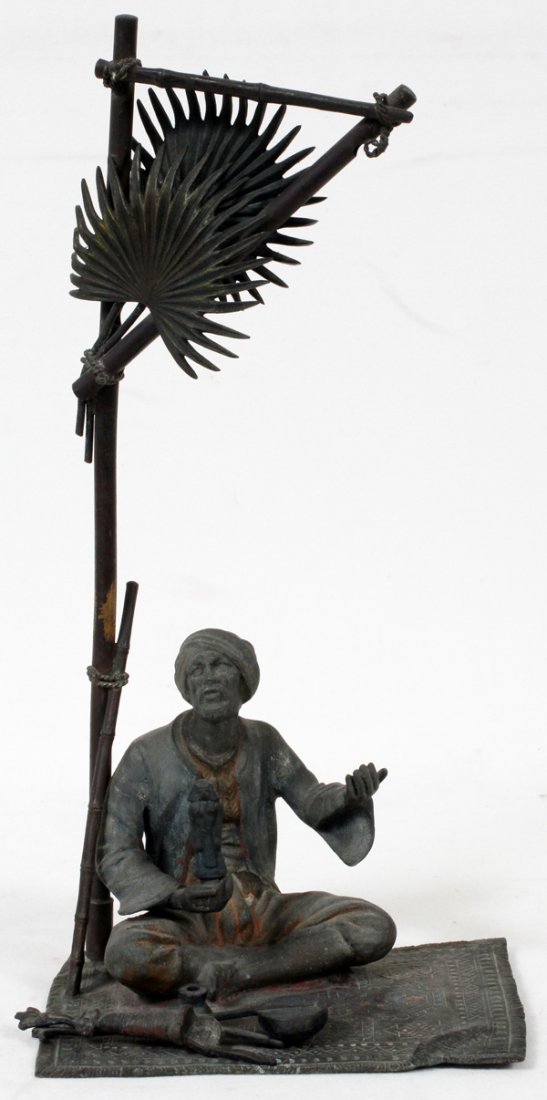 SPELTER FIGURAL LAMP, MANNER OF FRANZ BERGMAN: AUSTRIAN SPELTER FIGURAL LAMP IN THE MANNER OF FRANZ BERGMAN, H 13 1/2", L 6 1/2":Fashioned as a seated Arab man holding an Egyptian pharaoh statuette beneath a palm tree. Signed "BK" enclosed in a re