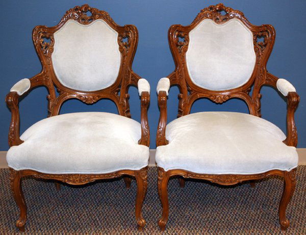 HAND CARVED WOOD, UPHOLSTERED FIRESIDE CHAIRS: HAND CARVED WOOD AND UPHOLSTERED FIRESIDE CHAIRS, C1930, PAIR:having carved crest, backrest, armrests, supports, seat frame and cabriolet legs. Newer light brown suede leather upholstery on back and a