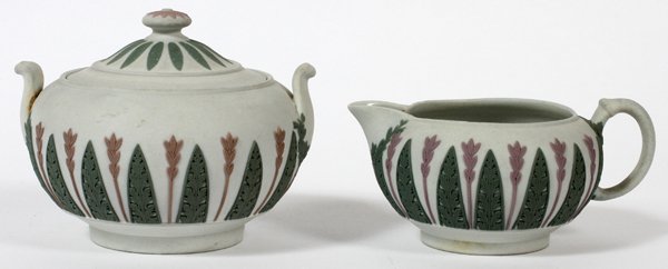 WEDGWOOD TRI-COLOR JASPERWARE SUGAR AND CREAMER: WEDGWOOD TRI-COLOR JASPERWARE COVERED SUGAR BOWL & CREAMER, H 4":having an off white ground with lavender floral design, spaced between green leaf patterns. Stamped 'Wedgwood' on the underside;