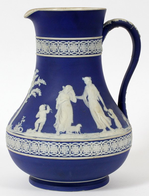 WEDGWOOD BLUE JASPERWARE PITCHER, LATE 19TH C.: WEDGWOOD BLUE JASPERWARE PITCHER, LATE 19TH C., H 9":Medium blue pitcher decorated in white cameo relief with allegorical figures, including Cupid, impressed "Wedgwood, England" (see additional photo)
