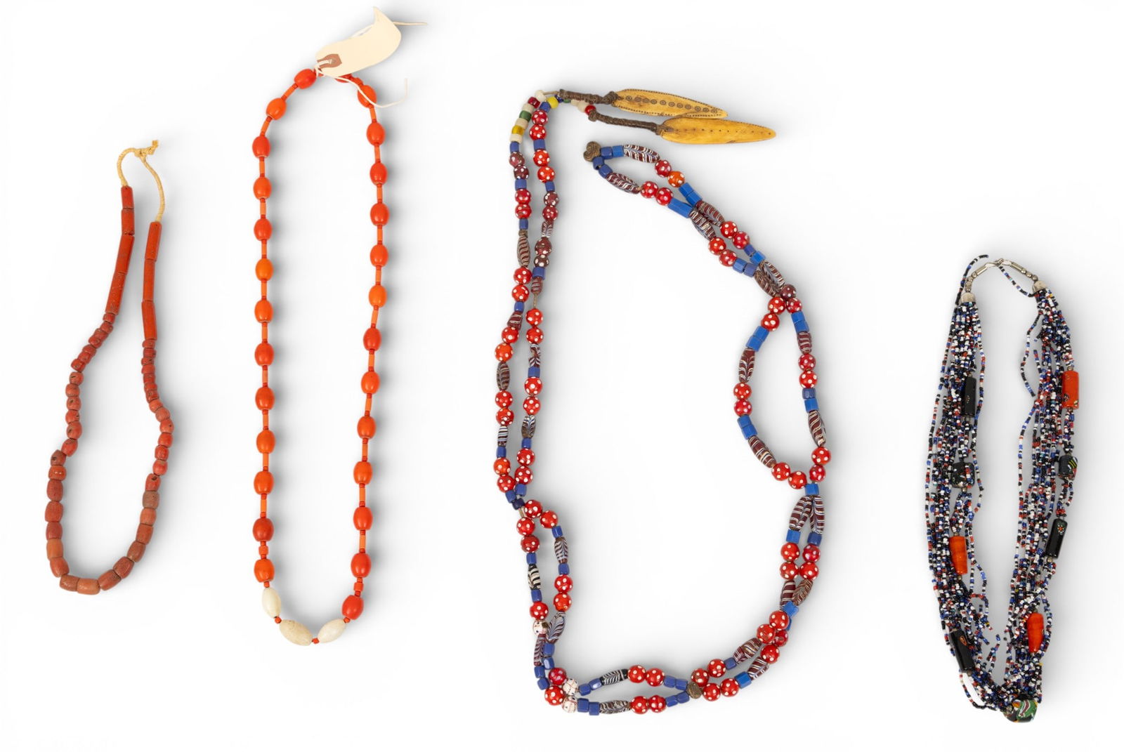 Four African Trade Bead Necklaces 4 PCS: Four African Trade Bead Necklaces 4 PCS Orange and white hardstone necklace (32"), orange hardstone necklace (24"), multistrand small bead necklace (24"), and one glass bead and bone necklace (80"). A