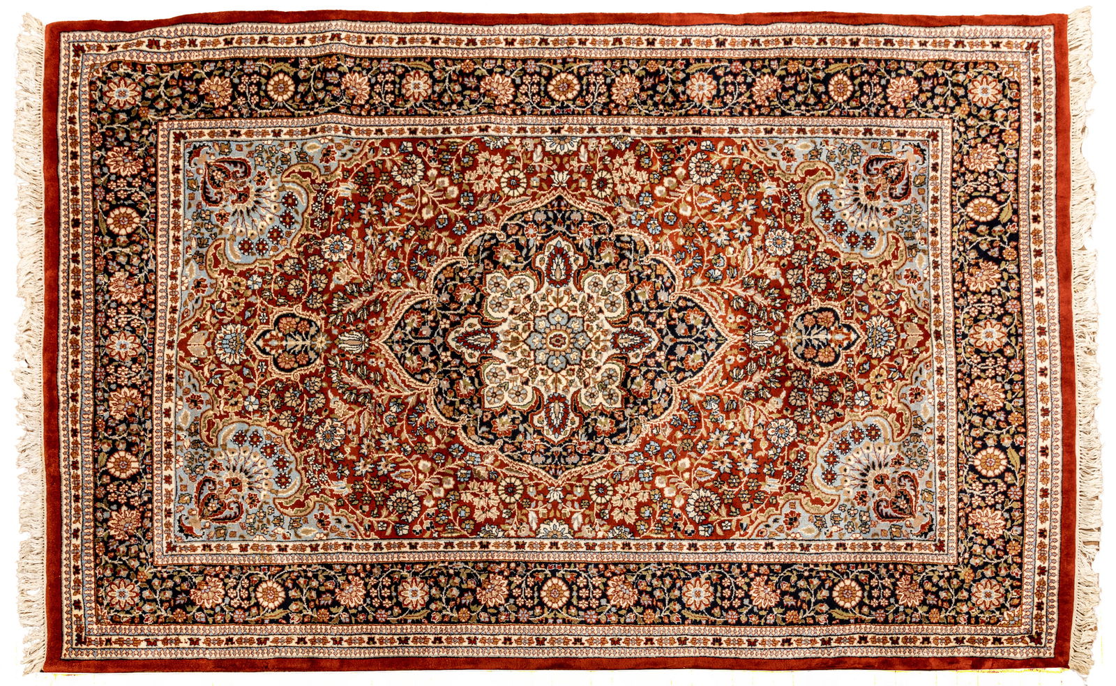 Indo-Kashan Handwoven Wool Rug, Ca. 1980, W 6' 7" L 11' 9": Indo-Kashan Handwoven Wool Rug, Ca. 1980, W 6' 7" L 11' 9" Having a rust central field with light blue brackets containing flowers in urns. Indigo outer border. All over floral patterns. Provenance: