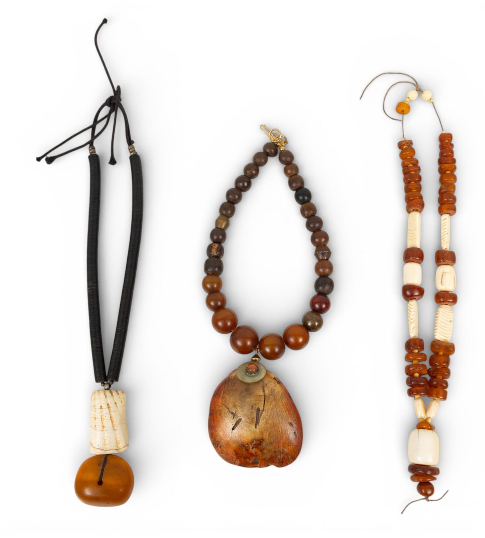 African Agate, Wood, Amber, and Bone Trade Bead Necklaces 3 PCS: African Agate, Wood, Amber, and Bone Trade Bead Necklaces 3 PCS Three African trade bead necklaces having agate, wood, amber, and bone beads. One with large shell pendant. Provenance: Property