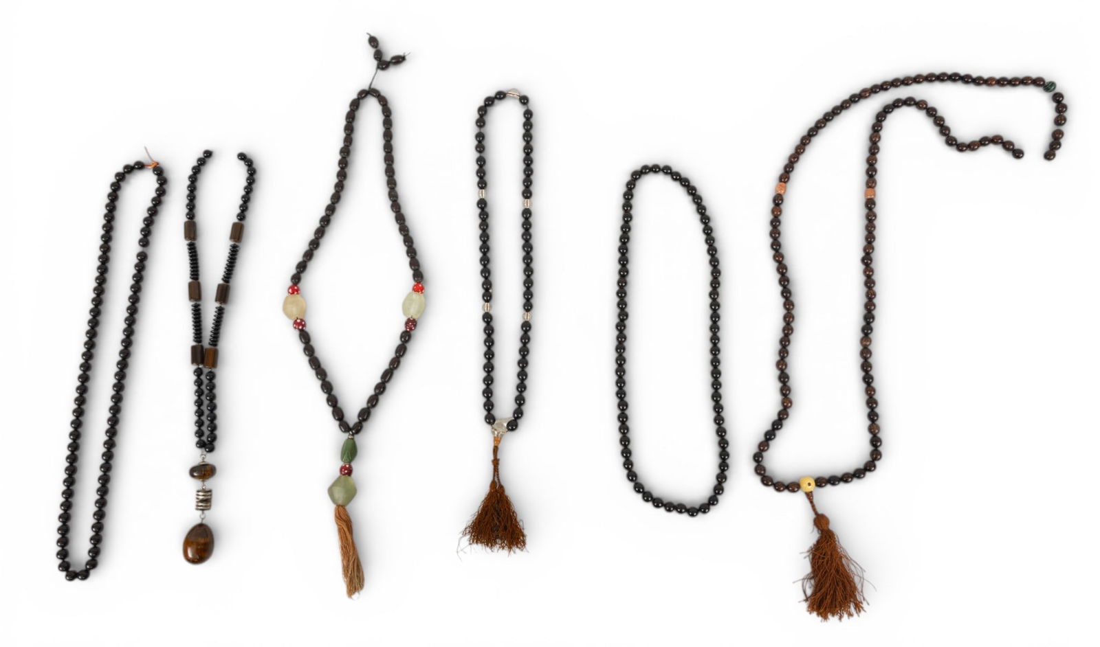 Seven African Ebony Wood and Hardstone Trade Bead Necklaces 7 PCS: Seven African Ebony Wood and Hardstone Trade Bead Necklaces 7 PCS A group of seven African trade bead necklaces composed of ebony wood, hardstone, glass, and resin beads. Some having silk cord tassels