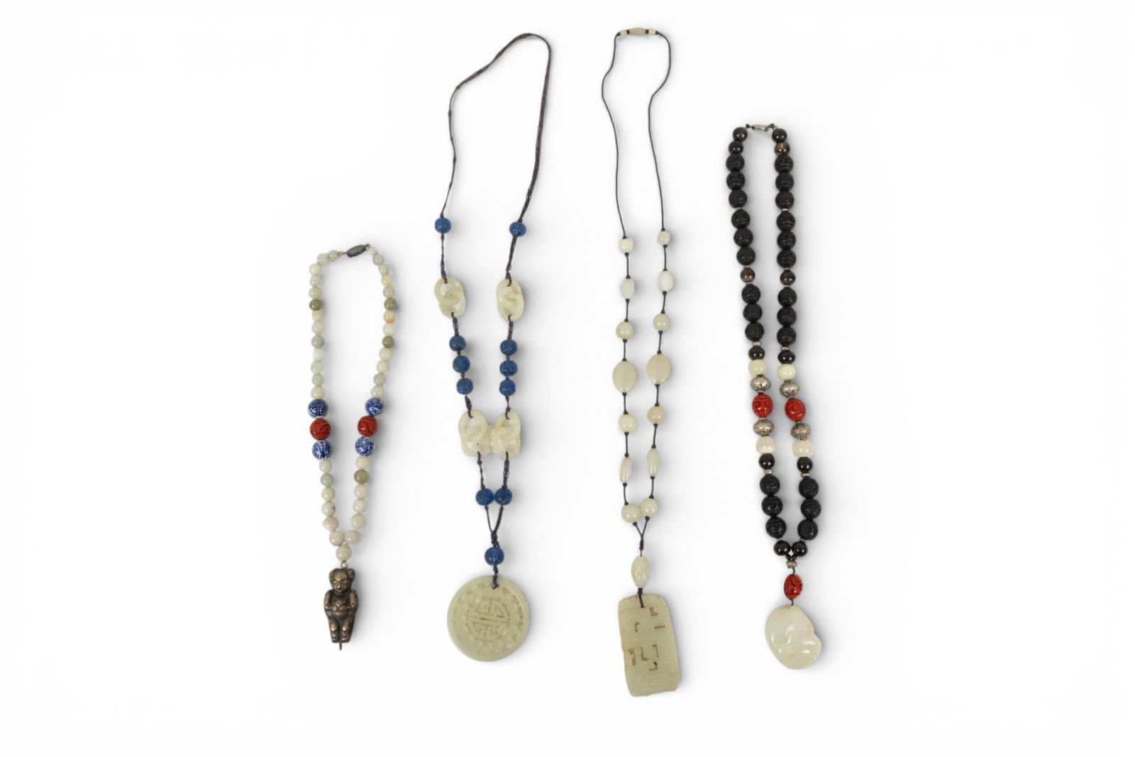 Four Nephrite Jade, Metal, Glass, Carved Ebony Wood and Cinnabar Beaded Necklaces 4 PCS: Four Nephrite Jade, Metal, Glass, Carved Ebony Wood and Cinnabar Beaded Necklaces 4 PCS Four beaded necklaces with various beads featuring nephrite jade and carved ebony wood and cinnabar. Provenance: