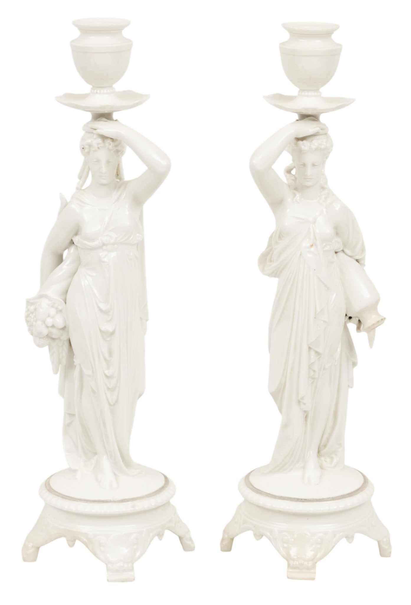 Italian Porcelain Figural Candlesticks 1910, H 19" Dia. 5.5": Italian Porcelain Figural Candlesticks 1910, H 19" Dia. 5.5" Pair of Grecian inspired maidens. One holding an amphora and the other a cornucopia. White glaze. Unmarked. Dimensions: H 19" Dia 5.5