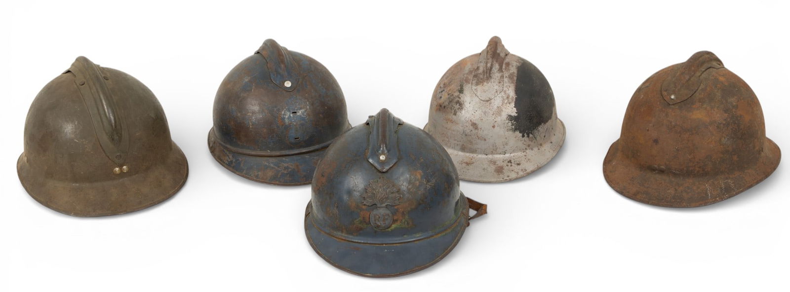 French M15 and M26 Steel Adrian Helmets, 1915-mid 20th C., H 6" W 8" L 11" 5 PCS: French M15 and M26 Steel Adrian Helmets, 1915-mid 20th C., H 6" W 8" L 11" 5 PCS Collection includes: (1.) M15 painted horizon blue. République Française infantry badge. With leather chi