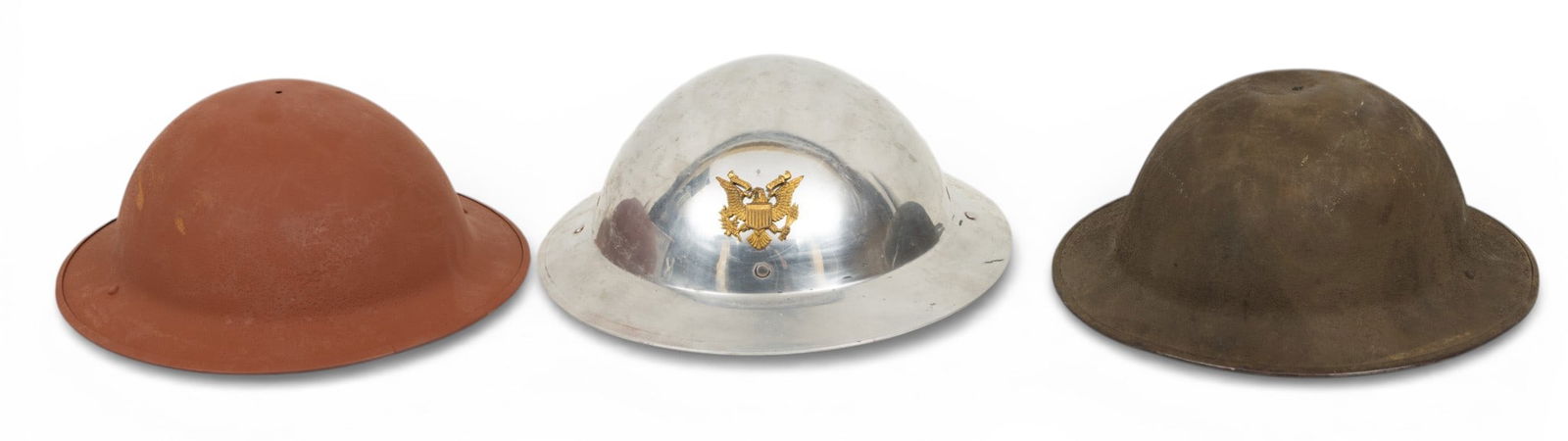 American Steel and Aluminum Brodie Helmets, Early to Mid 20th C., H 5" W 11.5" L 12.25" 3 PCS: American Steel and Aluminum Brodie Helmets, Early to Mid 20th C., H 5" W 11.5" L 12.25" 3 PCS Lot includes: (1.) M1917 painted olive drab. Oilcloth and fiber liner. Single rivet bales. (2.) Steel brod