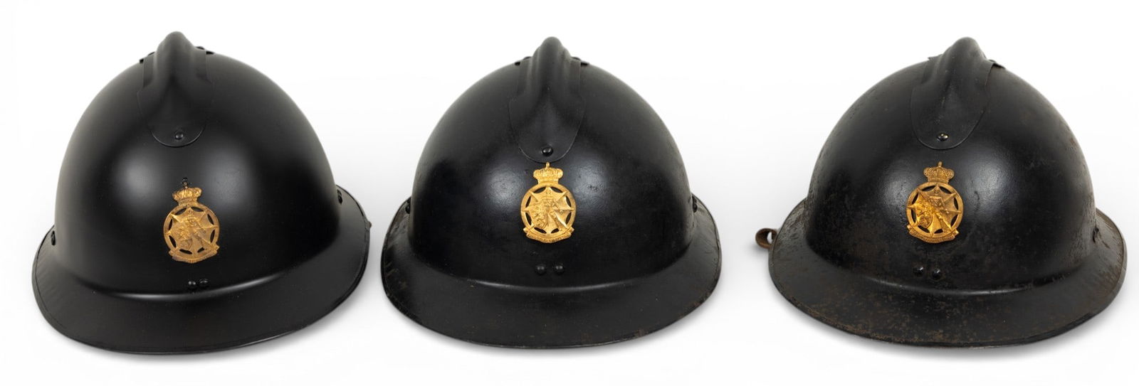 Belgian Steel Adrian Helmets, Ca. Early 20th C., H 6.5" W 8.5" Depth 12.5" 3 PCS: Belgian Steel Adrian Helmets, Ca. Early 20th C., H 6.5" W 8.5" Depth 12.5" 3 PCS French made Adrian helmets with the Belgian Civil Defense German occupation brass badge on the front. Badge reading "Im