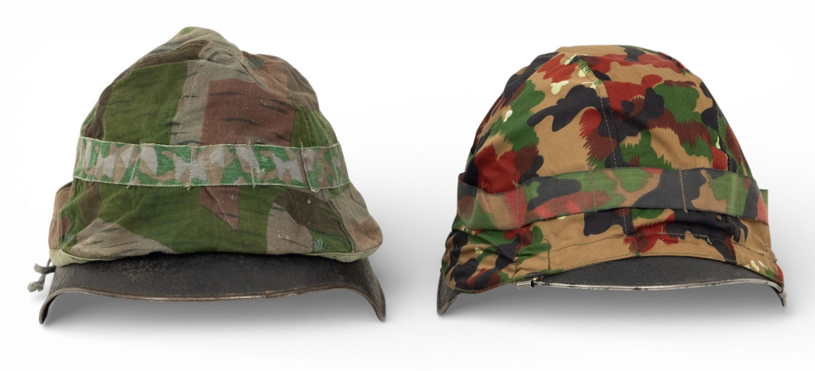 Swiss M18 Steel Helmets with Liners 1918-mid 20th C., H 6.5" W 9.75" Depth 12.25" 1 PAIR: Swiss M18 Steel Helmets with Liners 1918-mid 20th C., H 6.5" W 9.75" Depth 12.25" 1 PAIR Each with a camouflage cover and brown leather drawstring liners. Brown leather chinstraps. One mark