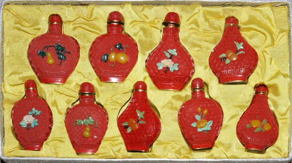 ORIENTAL CINNABAR AND JADE SNUFF BOTTLES, NINE: ORIENTAL CINNABAR AND JADE SNUFF BOTTLES, NINE:cinnabar snuff bottles with hardstone flower designs on the sides; all set in silk lined fitted box.