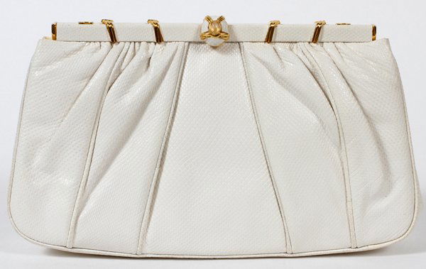 JUDITH LEIBER WHITE LIZARDSKIN EVENING BAG W 9": JUDITH LEIBER WHITE LIZARDSKIN EVENING BAG, W 9":Gold tone frame set with a single cabochon at the clasp, opening to white silk lining and gold tone shoulder strap. Stamped: Judith Leiber, Made in Spa