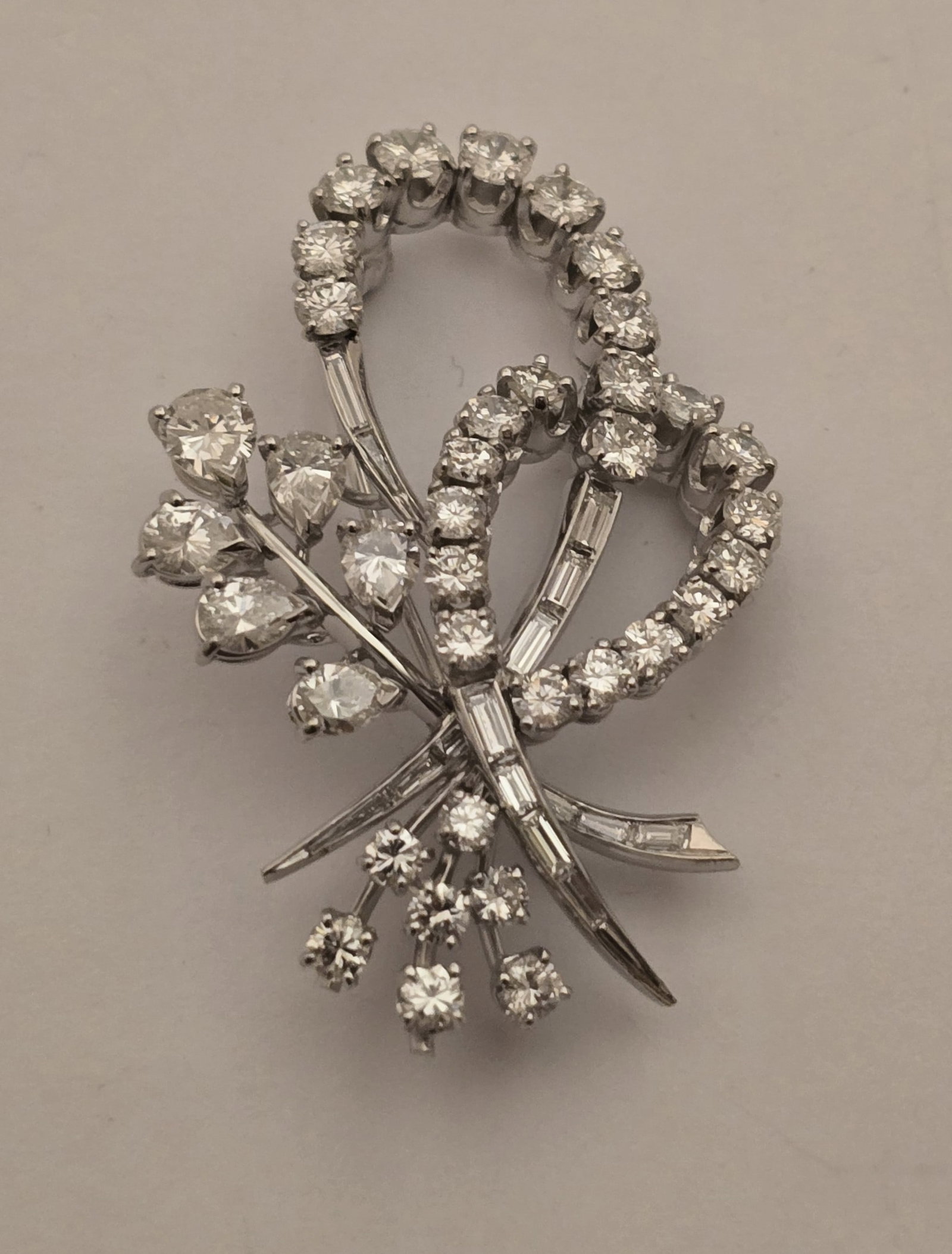 Vintage-Inspired Platinum and Diamond Ribbon Brooch H 1.75" 15.5 g: Vintage-Inspired Platinum and Diamond Ribbon Brooch H 1.75" 15.5 g A vintage-inspired style ribbon brooch having round, brilliant, pear, and baguette diamonds set in platinum. No apparent marks. 