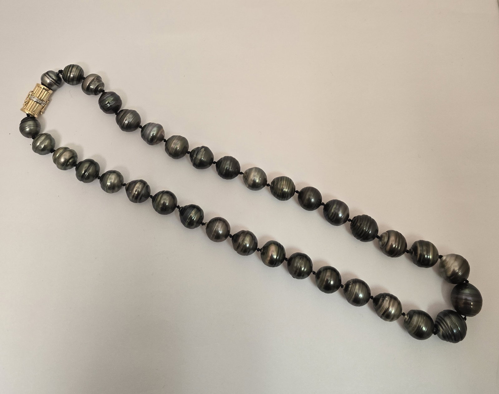 14k Yellow Gold and Diamond Clasp, Black Tahitian Pearl Necklace L 20": 14k Yellow Gold and Diamond Clasp, Black Tahitian Pearl Necklace L 20" A black, Tahitian pearl necklace knotted between each having a 14k yellow gold fluted barrel box clasp with round, brilliant diam