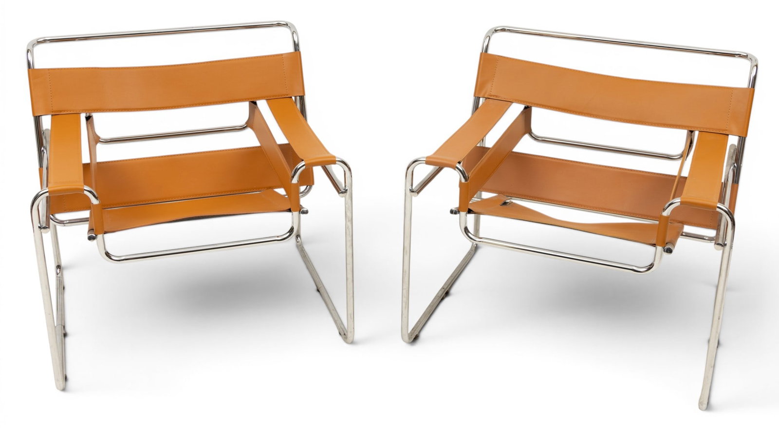 Marcel Breuer Design 'Wassily' Leather Arm Chairs, 20th Cent., H 28" W 30" Depth 28" 1 PAIR: Marcel Breuer Design 'Wassily' Leather Arm Chairs, 20th Cent., H 28" W 30" Depth 28" 1 PAIR No labels or apparent markings. Polished chrome tubular steel frame with light brown leather straps. P
