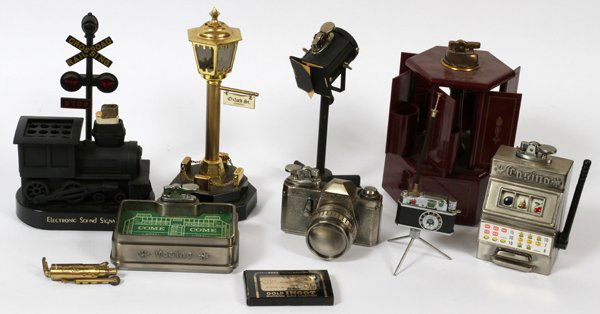 TRAIN, LIGHTS, CAMERAS, CAST METAL MINIATURES: TRAIN, LIGHTS, CAMERAS, ETC CAST METAL MINIATURE LIGHTERS, 10 PCS., H 1" - 6":includes a train crossing signal, spot light, street light, gold ingot, two cameras, one on tripod; slot machine, fire ext