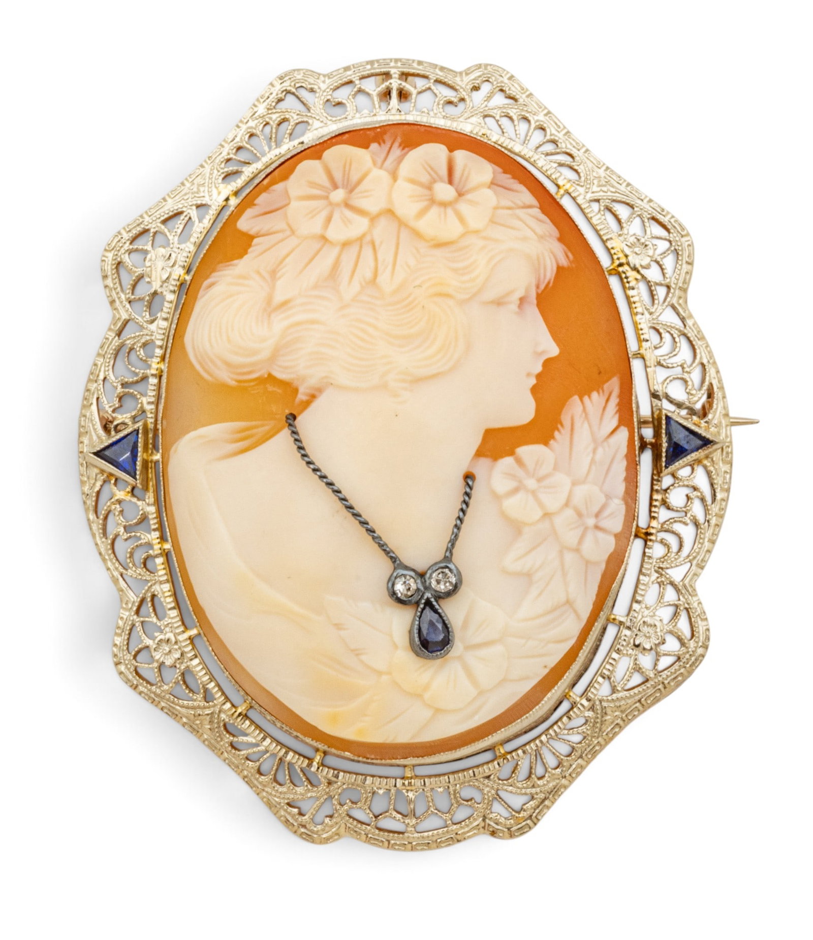 14KT White Gold Cameo Brooch/pendant 1900, H 2" W 1.5" 15 grams 1 PC: 14KT White Gold Cameo Brooch/pendant 1900, H 2" W 1.5" 15 grams 1 PC Hand crafted bezel set antique Flora Lady Shell Cameo accented with sapphires and diamond. Depicts a lady with flowers in her