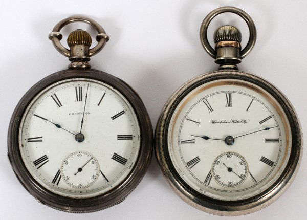 VINTAGE HAMPDEN, WALTHAM CHAMPION POCKET WATCHES: VINTAGE HAMPDEN & WALTHAM CHAMPION OPEN FACE POCKET WATCHES, TWO:The Hampden watch has a rose gold inlay of a locomotive on the back of the case. The Waltham Champion watch has a coin silver case with