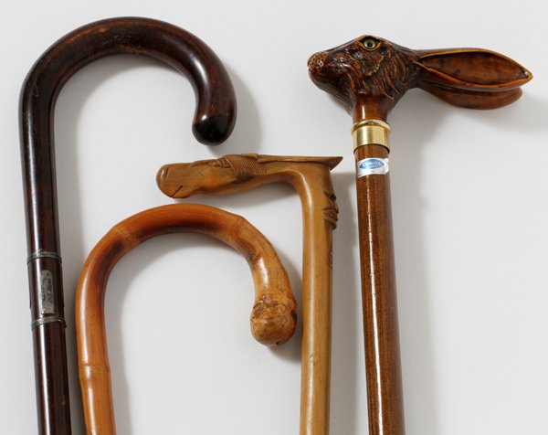 WOOD WALKING STICKS, FOUR: WOOD WALKING STICKS, FOUR:One bamboo with incised carving, one wood with silver inlay on shaft, one with horse head, one with rabbit head made in Italy for Comoy of London with glass eyes.