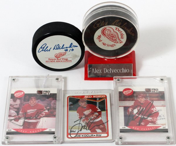 DETROIT RED WINGS AUTOGRAPHED PUCK TRADING CARDS: DETROIT RED WINGS AUTOGRAPHED PUCKS AND TRADING CARDS, 5 PCS., DELVECCHIO, KOCUR AND PROBERT: includes two Detroit Red Wing hockey pucks signed by Alex Delvecchio, on signed on a Detroit Red Wings Alu