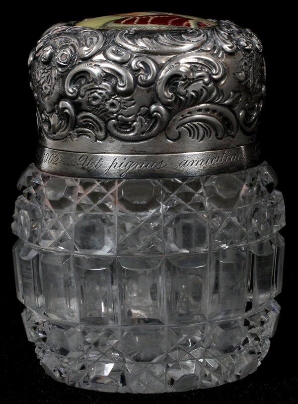 CUT GLASS & STERLING PORTRAIT INKWELL C. 1902: CUT GLASS & STERLING PORTRAIT INKWELL, C. 1902, H 3", DIA 2 1/4": A round cut glass jar with sterling silver collar and hinged lid with repousse scroll and floral motif, centered by an enameled portra