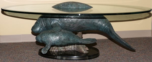 ROBERT WYLAND BRONZE W/ GLASS TOP TABLE: ROBERT WYLAND BRONZE WITH GLASS TOP TABLE H 23" L 61" D 41", "ABOVE AND BELOW MANATEES": Robert Wyland [American B.1956] studied at the College For Creative Studies, Detroit, MI. Edition numbered AP 6