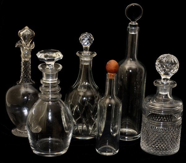 CRYSTAL DECANTERS 6 PIECES: CRYSTAL DECANTERS, 6 PIECES, H 9 1/2''-14 1/2'':One signed VSL for Val St Lambert [second from left with three neck rings]; Far left: pedestal base with hand cut honeycomb neck, hollow stopper is chip