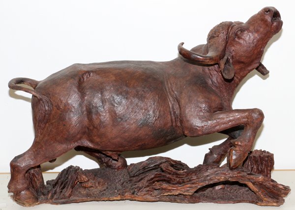 AFRICAN HAND CARVED HARDWOOD CAPE BUFFALO: AFRICAN, HAND CARVED HARDWOOD, CAPE BUFFALO, H 24", L 36":hand carved hardwood sculpture of an African Cape Buffalo with it's head raised and bellowing. On integral base.