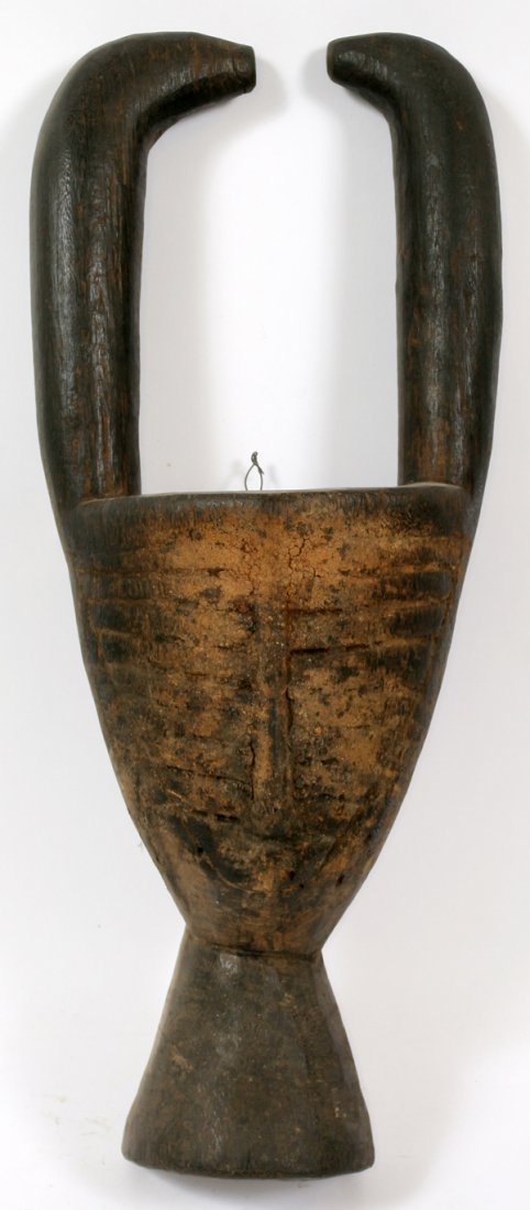 AFRICAN TOMA TRIBE CARVED WOOD MASK: AFRICAN TOMA TRIBE CARVED WOOD MASK, H 25" W 9 1/2":From the Toma tribe. Having linear carved detailing to the face, with a slender, elongated nose at the center. The mask has two raised inward pointi