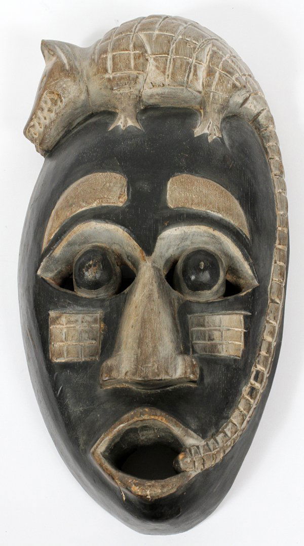 AFRICAN CARVED POLYCHROME ARMADILLO TRIBAL MASK: AFRICAN CARVED POLYCHROME ARMADILLO TRIBAL MASK, H 14 1/4'', L 7'': Being of an oval form, with an open mouth, wide set nose, and large, googly style eyes. A raised figural armadillo is mounted at the