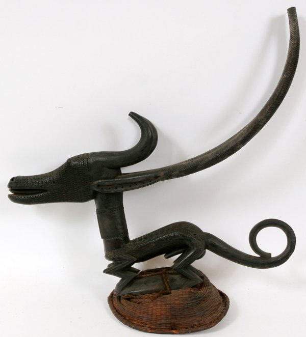 BAMBARA TRIBE CHI WARA ANTELOPE HEADDRESS: AFRICAN BAMBARA TRIBE, CHI WARA ANTELOPE HEADDRESS, H 20" W 22":From the Bambara tribe, Mali, Africa. Headdress has a slenderly carved figural antelope, raised above a woven basket skull cap.