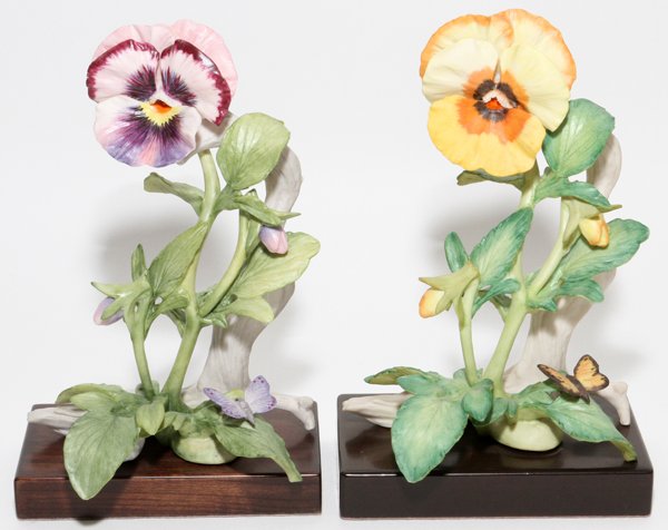 CYBIS BISQUE PANSIES TWO: CYBIS BISQUE PANSIES, TWO, H 7 1/4":Including 1 purple pansy and 1 yellow pansy, each with a butterfly and mounted on a wood base, signed and numbered 614 and 586, respectively.