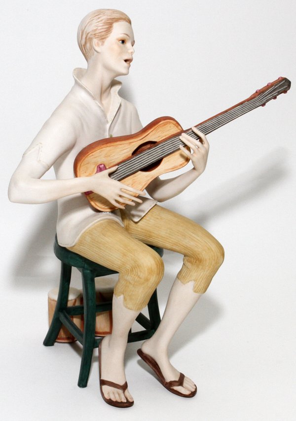 CYBIS BISQUE FIGURE OF SEATED MUSICIAN #31: CYBIS BISQUE FIGURE OF SEATED MUSICIAN, #31, H 12":Depicting a seated man playing the banjo, with separate wood base. Signed and numbered on drums.