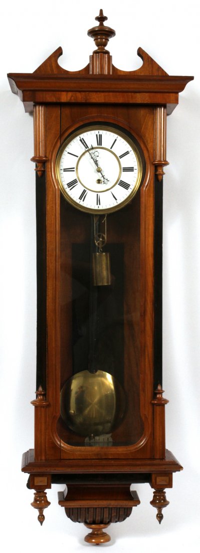 VIENNESE WALL CLOCK: VIENNESE WALL CLOCK, L 39 1/2":Having a Roman numeral clock face, keywind, one brass weight, and a black lacquer and brass pendulum. Case has carved decoration, and black lacquer sides.