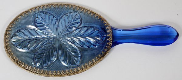 BLUE GLASS HAND MIRROR C. 1910: BLUE GLASS HAND MIRROR, C. 1910, L 11 1/4":Art Deco. Decorated in a finely patterned gold gilt overlay along mirror's edge, with a pressed glass flower centered on the back. From the Rana Family. Circ