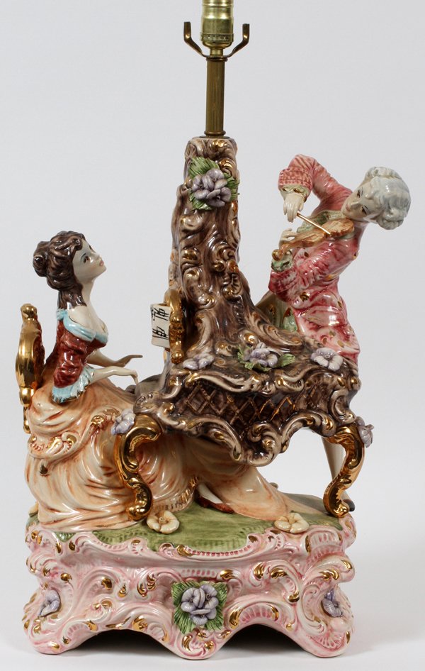 ITALIAN PORCELAIN FIGURAL TABLE LAMP 42 OVERALL: ITALIAN PORCELAIN FIGURAL TABLE LAMP, H 21", 42" OVERALL:Italian porcelain figural table lamp depicting a man playing a violin and a woman playing a spinet. Porcelain 21" H. with fittings, 42" H.