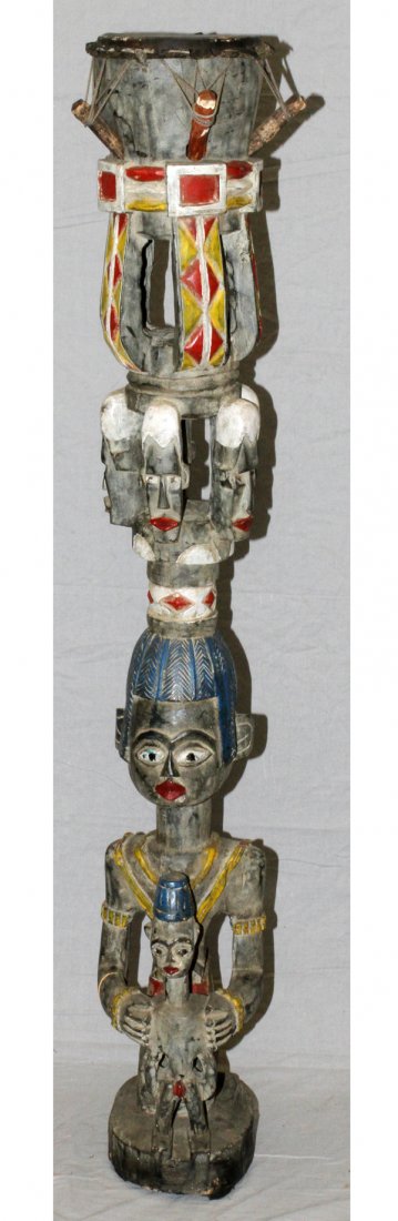 AFRICAN BAGA POLYCHROME CEREMONIAL DRUM GUINEA: AFRICAN BAGA CARVED POLYCHROME CEREMONIAL DRUM, H 63" W 20", GUINEA:Decorated in black, white, blue, red, and yellow pigments, with a carved figural base of father and child, below a tier of masks; fe