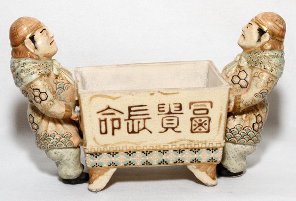 JAPANESE SATSUMA EARTHENWARE PLANTER MEIJI PERIOD: JAPANESE SATSUMA EARTHENWARE FIGURAL PLANTER, MEIJI PERIOD, H 4 1/4", W 7":Signed on front of planter. Hand painted. Two standing figures serve as decorative supports. 19th.c.