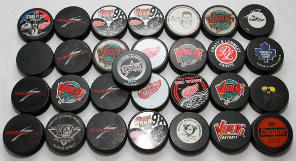 RED WINGS DETROIT VIPERS TORONTO MAPLE LEAFS PUCKS: DETROIT RED WINGS, DETROIT VIPERS, TORONTO MAPLE LEAFS ASSORTED HOCKEY PUCKS (29):Including Commemorative Stanley Cup pucks, and many others. All unsigned.