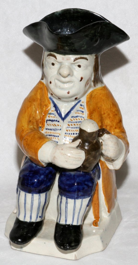 ENGLISH PEARLWARE TOBY JUG C. 1800: ENGLISH PEARLWARE TOBY JUG, C. 1800, H 9", PRATT COLORS:Modeled in a seated position with a frothing jug on his knee, spots on his face. Provenance: Leo Kaplan, New York.