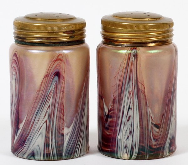 IRIDESCENT ART GLASS SALT & PEPPER SHAKERS PAIR: IRIDESCENT ART GLASS SALT & PEPPER SHAKERS, PAIR, H 3 1/4":In the style of Loetz. Having an iridescent sheen, decorated in pulled form designs along the base. Mounted with gold washed lids, measuring