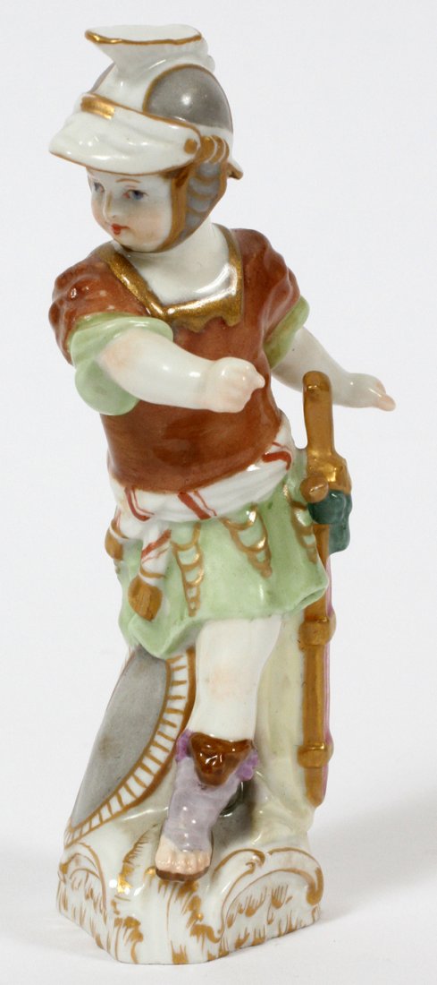 KPM PORCELAIN FIGURE C. 1920: KPM PORCELAIN FIGURE, C. 1920, H 4 3/4":A cherubic boy dressed as a Roman soldier with shield at his feet; marked in blue under glaze with a scepter, red KPM orb mark, and numbered 140/462 (see additi