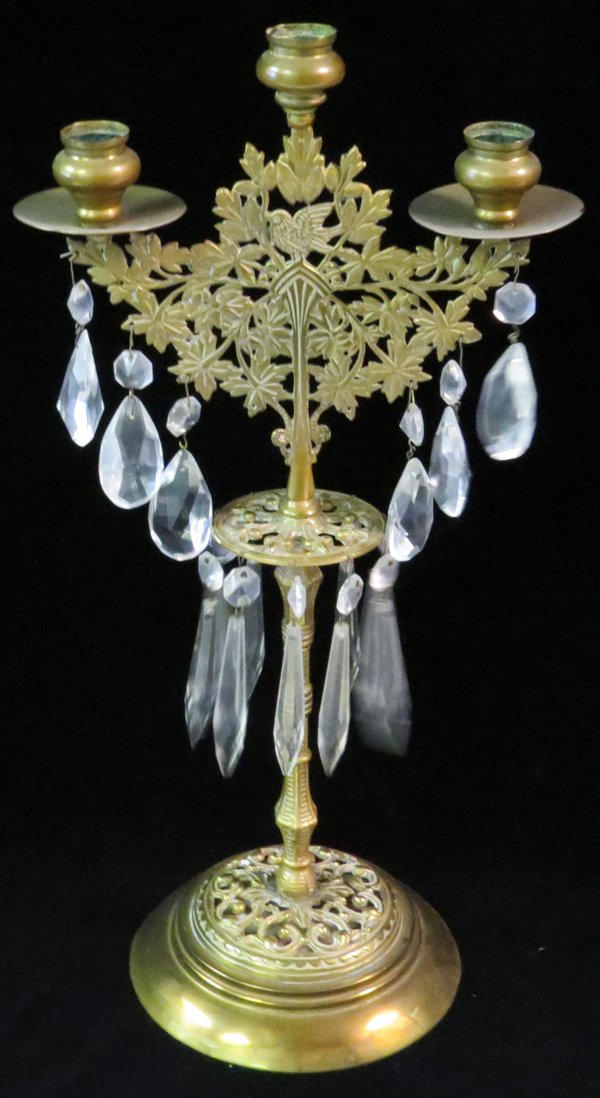 BRASS & CRYSTAL 3-LIGHT CANDELABRA: BRASS & CRYSTAL 3-LIGHT CANDELABRA, H 17'':Decorated with a pierced branch and leaf motif, having a single bird figure at the center. Hung with two tiers of crystal prisms. Measuring H. 17" x 8 1/2".