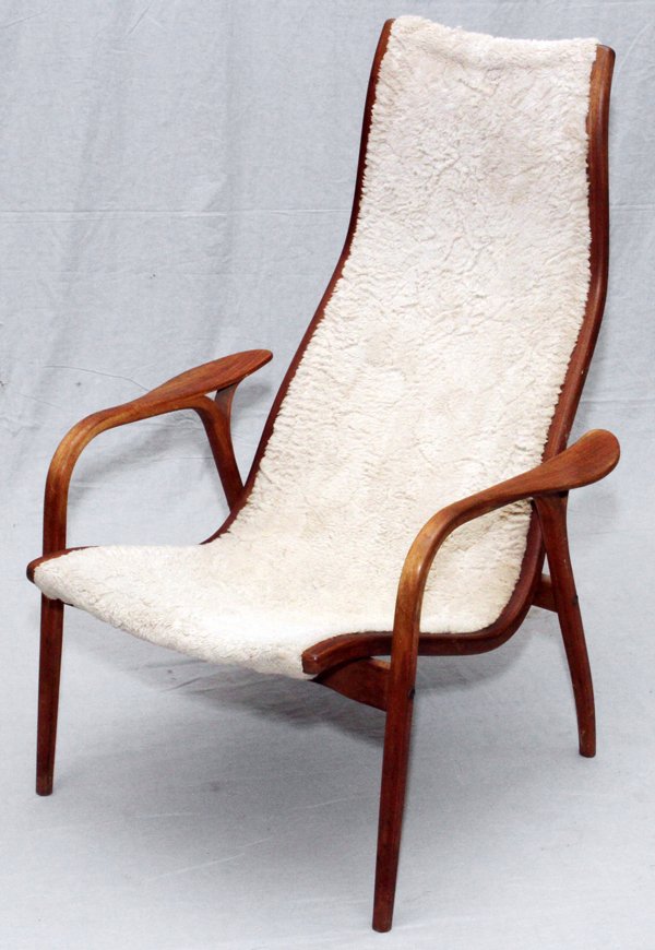 YNGVE EKSTROM SWEDISH SHEEPSKIN LOUNGE CHAIR: YNGVE EKSTROM SWEDISH SHEEPSKIN LOUNGE CHAIR, H 39", W 27", D 30":Mid Century modern teakwood lounge chair by Ekstrom, with a sheepskin upholstered seat and back. Unmarked, measuring H. 39" x 27" x 30