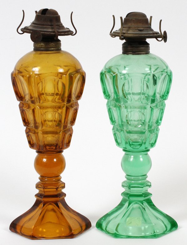 AMERICAN PRESSED GLASS STAND LAMPS, TWO: AMERICAN PRESSED GLASS FOUR-PRINTIE BLOCK STAND LAMPS, TWO, H 10"-11":Including one colored in green, the other in amber, both featuring dome form tops, in a four-printie block pattern, having round k