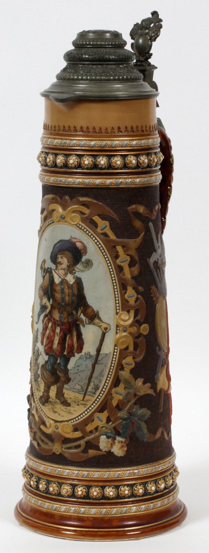 METTLACH STONEWARE STEIN VILLEROY & BOCH C. 1887: METTLACH STONEWARE STEIN, VILLEROY & BOCH, C. 1887, H 22", #1562:A cylindrical stoneware stein with flaring sides, pewter cover and thumb lift, with a single oval reserve enclosing a cavalier standing