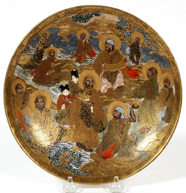 JAPANESE SATSUMA SHALLOW BOWL MEIJI PERIOD: JAPANESE SATSUMA SHALLOW BOWL, MEIJI PERIOD (1868-1912), DIA 8 1/2":A round earthenware bowl hand decorated in gilt and polychrome with Buddhist holy men and other figures in a landscape with temple i