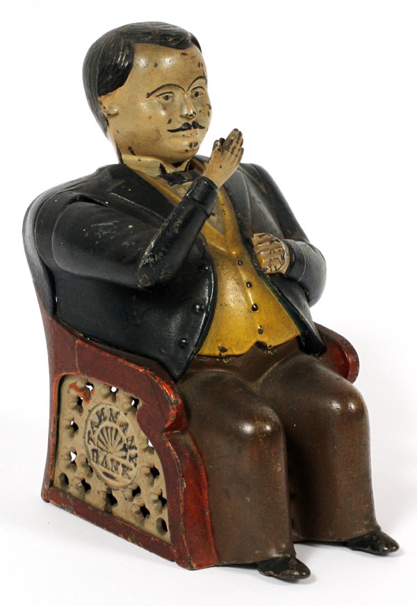 'TAMMANY BANK' MECHANICAL METAL BANK C1880: 'TAMMANY BANK', MECHANICAL METAL BANK, C1880, H 7", W 3 1/2":Man seated. In chair with pierced design and medallion inscribed: 'Tammany Bank'. Circa 1880’s You would place a coin in his hand and its